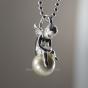 Necklace with mini sitting guardian angel on a white pearl